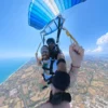 Passeggera durante il volo con paracadute tandem aperto sopra le Marche