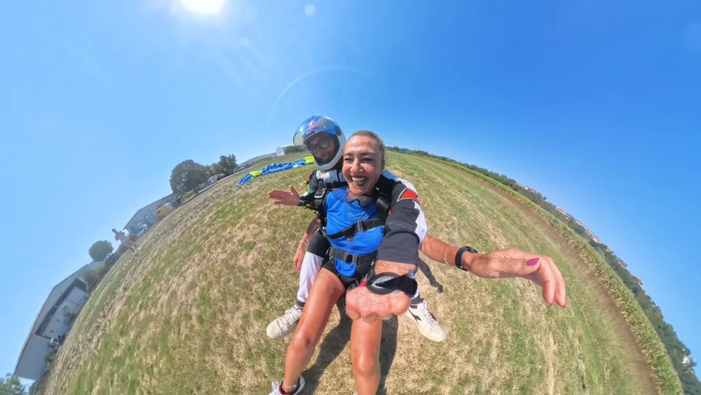Dopo l’atterraggio del lancio tandem Passeggera sorridente con istruttore dopo l’atterraggio del lancio tandem a Fermo