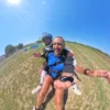 Dopo l’atterraggio del lancio tandem Passeggera sorridente con istruttore dopo l’atterraggio del lancio tandem a Fermo