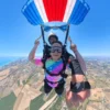 Volo tandem con paracadute aperto Passeggera durante il volo con il paracadute tandem aperto sopra le Marche